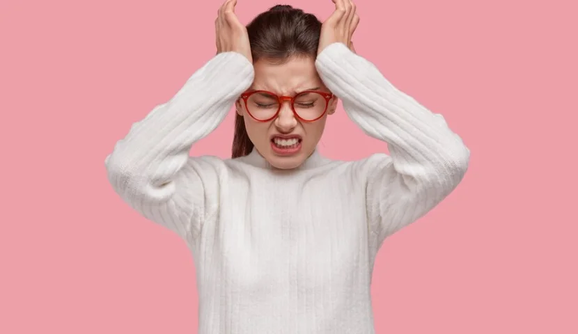 девушка держится за голову из-за панической атаки